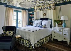 a bedroom with blue walls and white bedding has a chandelier hanging from the ceiling