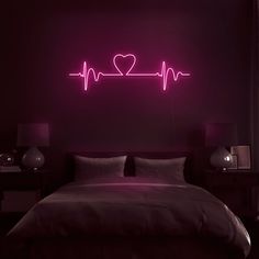 a bed in a room with a lit up heart on the wall above it and two nightstands