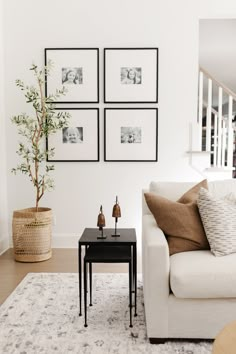 a living room with pictures on the wall and a coffee table in front of it