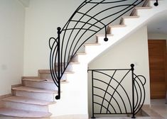 a spiral staircase with wrought iron railing and handrails in a home entryway