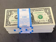 stacks of one hundred dollar bills wrapped in blue and white ribbon on top of each other