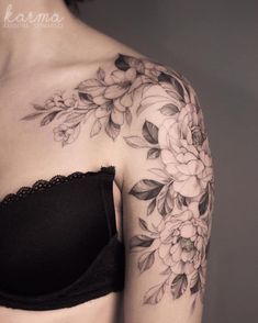 a woman's shoulder with flowers and leaves on the back of her bra top