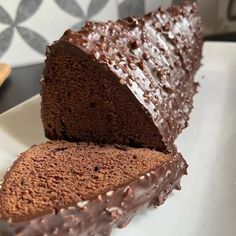 a loaf of chocolate cake sitting on top of a white plate