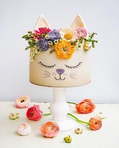 a cake decorated with flowers and a cat's face