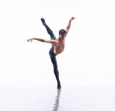 a shirtless man is dancing in the water with his legs spread out and one leg bent