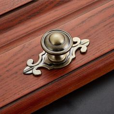 a close up of a door handle on a wooden surface