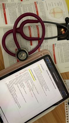 a tablet with a stethoscope on top of it next to medical books