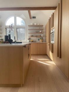 an open kitchen with wooden cabinets and white counter tops, along with hardwood flooring