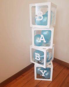 three plastic boxes stacked on top of each other with letters and balloons in the middle