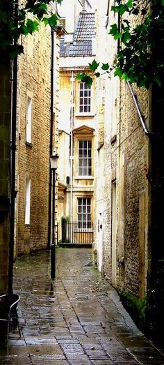 an alley way with stone buildings and trees