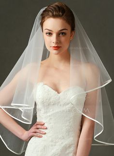 a woman in a wedding dress with a veil on her head