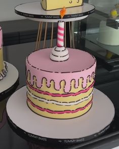 there are three cakes that have candles on top of them, one is pink and the other is yellow