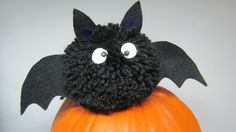 a stuffed bat sitting on top of a pumpkin