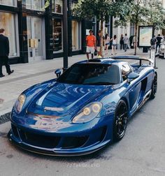 a blue sports car is parked on the street