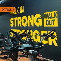 there are many exercise bikes lined up on the floor in front of a wall that says, walk in strong out bigger