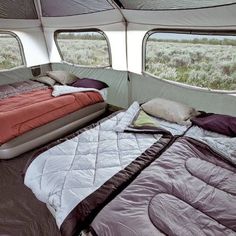 the inside of a tent with two beds and an air mattress on it's side