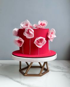 a red cake with pink flowers on top