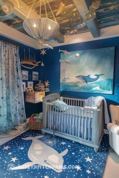 a baby's room decorated in blue and white with stars on the ceiling, crib bedding, rocking chair, dresser and painting