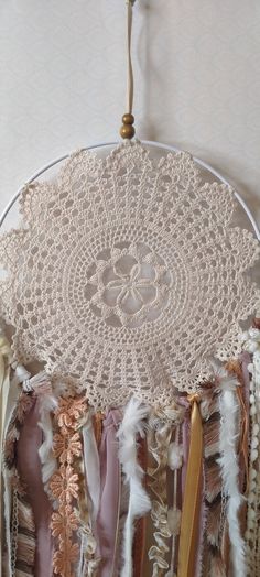 a white doily with feathers hanging from it