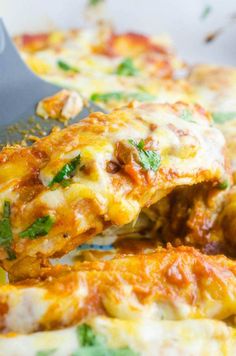 a spatula scooping some food out of a casserole dish with cheese and spinach