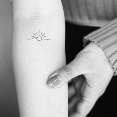 a woman with a small sun tattoo on her arm