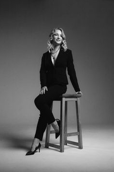 a woman sitting on top of a wooden stool