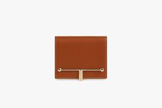 A true statement piece, the Melville Street Wallet features the instantly recognisable signature Strathberry bar, which functions as a secure lock. Handcrafted in Spain from smooth calf leather to a compact square dimension, it unfolds to reveal three card slots and a zipped coin pocket with a leather pull. This colorway is exclusive to Fall/Winter 2022. Elegant Tan Wallets For Business, Chic Brown Business Wallet, Elegant Tan Rectangular Wallet, Elegant Tan Bifold Wallet, Elegant Everyday Tan Wallet, Modern Rectangular Wallets For Work, Modern Tan Leather Wallet, Chic Brown Card Holder, Elegant Trifold Wallet With Smooth Grain