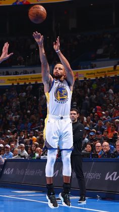 a basketball player is jumping up to dunk the ball in front of an audience