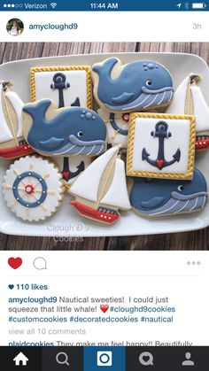 some decorated cookies are on a plate with an anchor and whale design in the middle