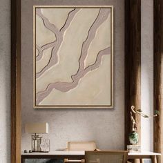 an abstract painting hangs on the wall above a dining room table with chairs and a lamp