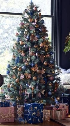 a decorated christmas tree in front of a window