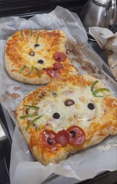 two pizzas sitting on top of wax paper