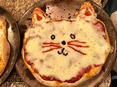 two pizzas that have been decorated to look like cats