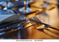 forks and knives on a wooden table in a restaurant