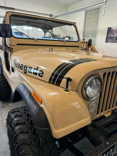 an old jeep is parked in a garage