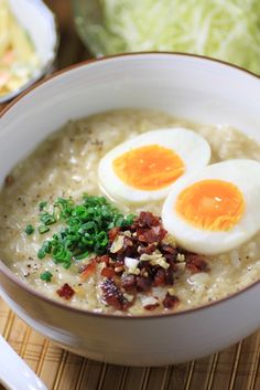 two eggs are sitting on top of some oatmeal in a white bowl