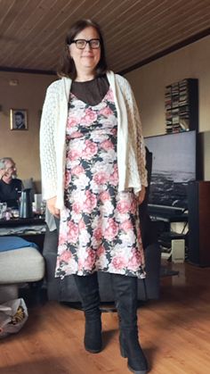 a woman standing in a living room next to a couch