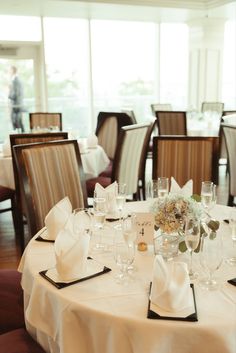 the table is set with wine glasses and place settings