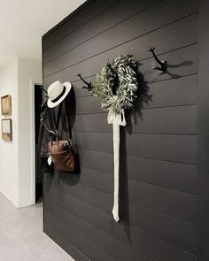 there is a coat rack on the wall with hats and purses hanging from it