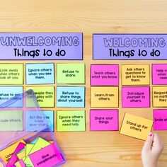 a person is holding up some sticky notes on a table with other things to do in front of them