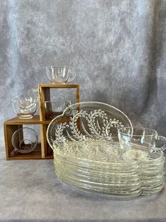 several glass dishes are stacked on top of each other in front of a gray background