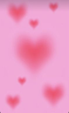 a blurry image of hearts on a pink background