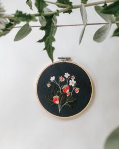 a black and red floral embroidery on a white wall