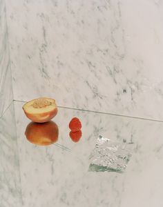 a piece of fruit sitting on top of a glass table