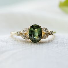 The ring made  in 14K Yellow gold is one of a kind and ready to ship after resizing. Be special with our green sapphire ring !  Oval cut sapphire ring is made of solid yellow gold with marquise diamonds in a unique style.  Feel free to contact me for your own ideas, I will be happy to create custom ring for you.✨ Ring details: Weight: 3.3g Material: 14K Yellow gold Central gemstone: Type: Natural sapphire Carat weight(approx.): 1.5ct Measurements: 7.96x5.86mm Color grade: Green  Shape: Oval Side diamonds: Shape: Marquise Size: 4x2mm Quantity: 4 Color: G Clarity: SI1 Carat weight: 0,4ct Side diamonds: Shape: Round Size: 1.5mm Quantity: 2 Color: G Clarity: SI1 Carat weight: 0,022ct 🛠Handcrafted with love from our workshop in Prague.🛠 CERTIFICATION📃 Each piece of jewelry is provided with c Blue Green Sapphire Ring, Diamond Ring Oval, Green Diamond Rings, Nature Inspired Engagement Ring, Green Sapphire Engagement Ring, Green Sapphire Ring, Cute Engagement Rings, Future Engagement Rings, Blue Green Sapphires