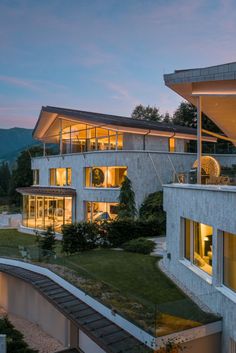 an exterior view of a modern house at dusk with stairs leading up to the upper level