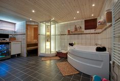 a bathroom with a large tub, sink and television on the wall next to it