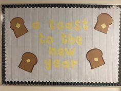 a toast to the new year bulletin board with bread on it and words written in yellow