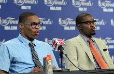 two men sitting in front of microphones at a press conference