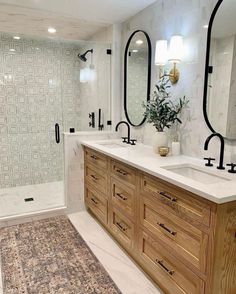 a large bathroom with two sinks and mirrors on the wall next to a walk in shower